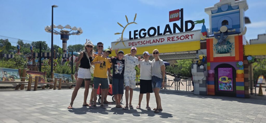 Fabian mit Familie und Begleitpersonen am Eingang des LEGOLAND Feriendorfs.