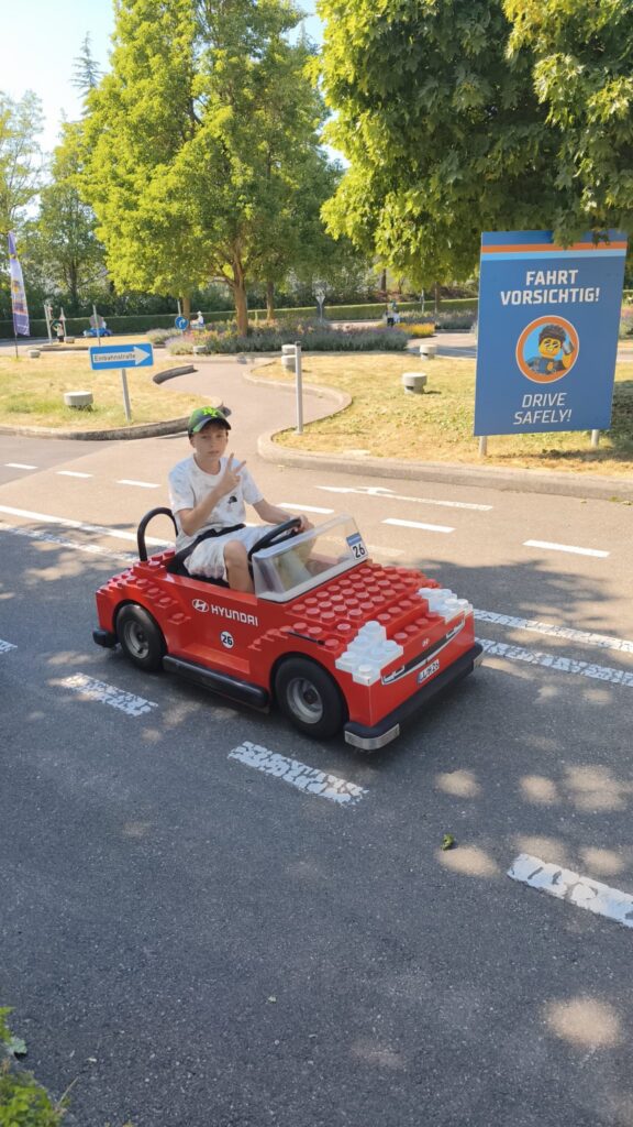 make-a-wish-oesterreich_erfuellte-wuensche_Fabian (7) Fabian fährt bei seiner Make-A-Wish-Wunscherfüllung ein rotes LEGO-Auto.