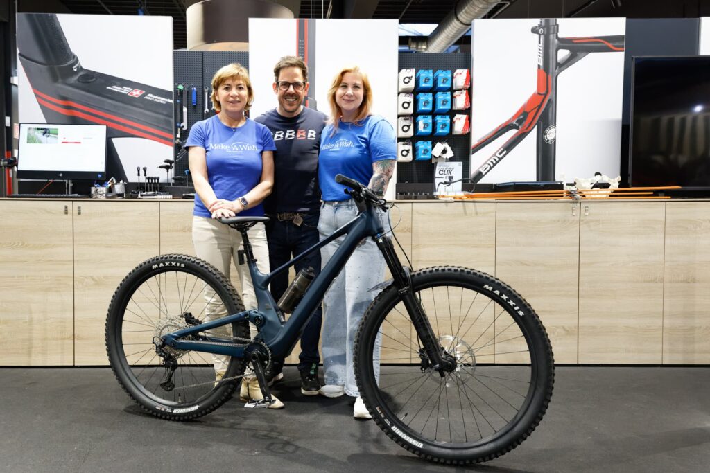 make-a-wish-oesterreich_erfuellte-wuensche_Daniel (1) Wunscherfüllerinnen Ursula und Clarissa mit Spender Bernhard Kohl hinter Daniels dunkelblauem Mountainbike